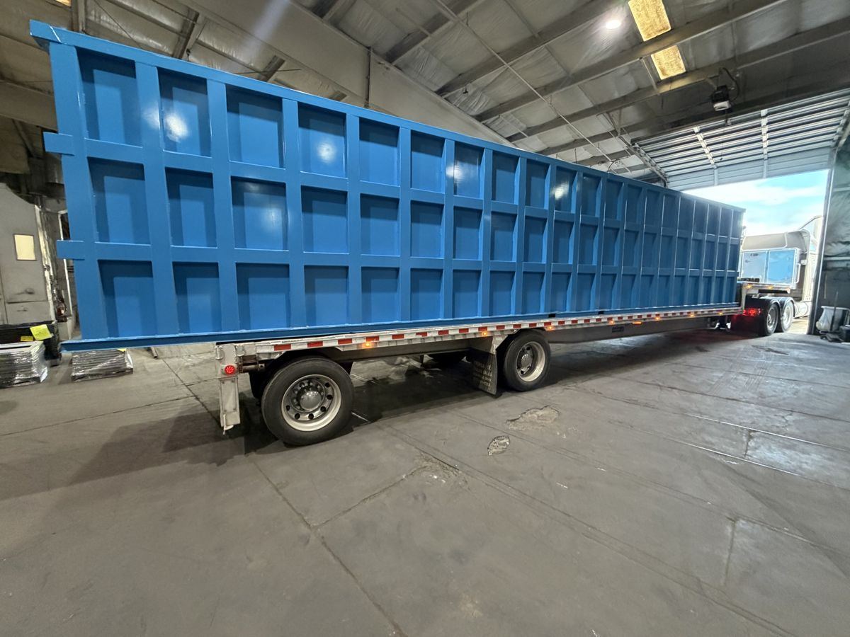 A finished EnviroBox module loaded on a standard flatbed trailer