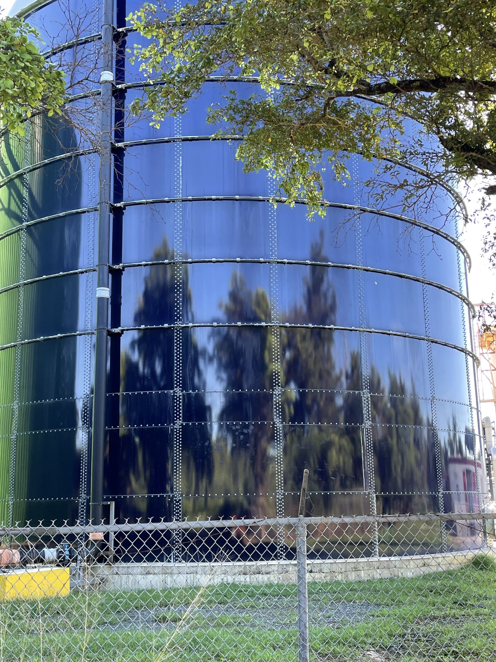 Glass-fused-to-steel bolted tank shell viewed from outside the site fence