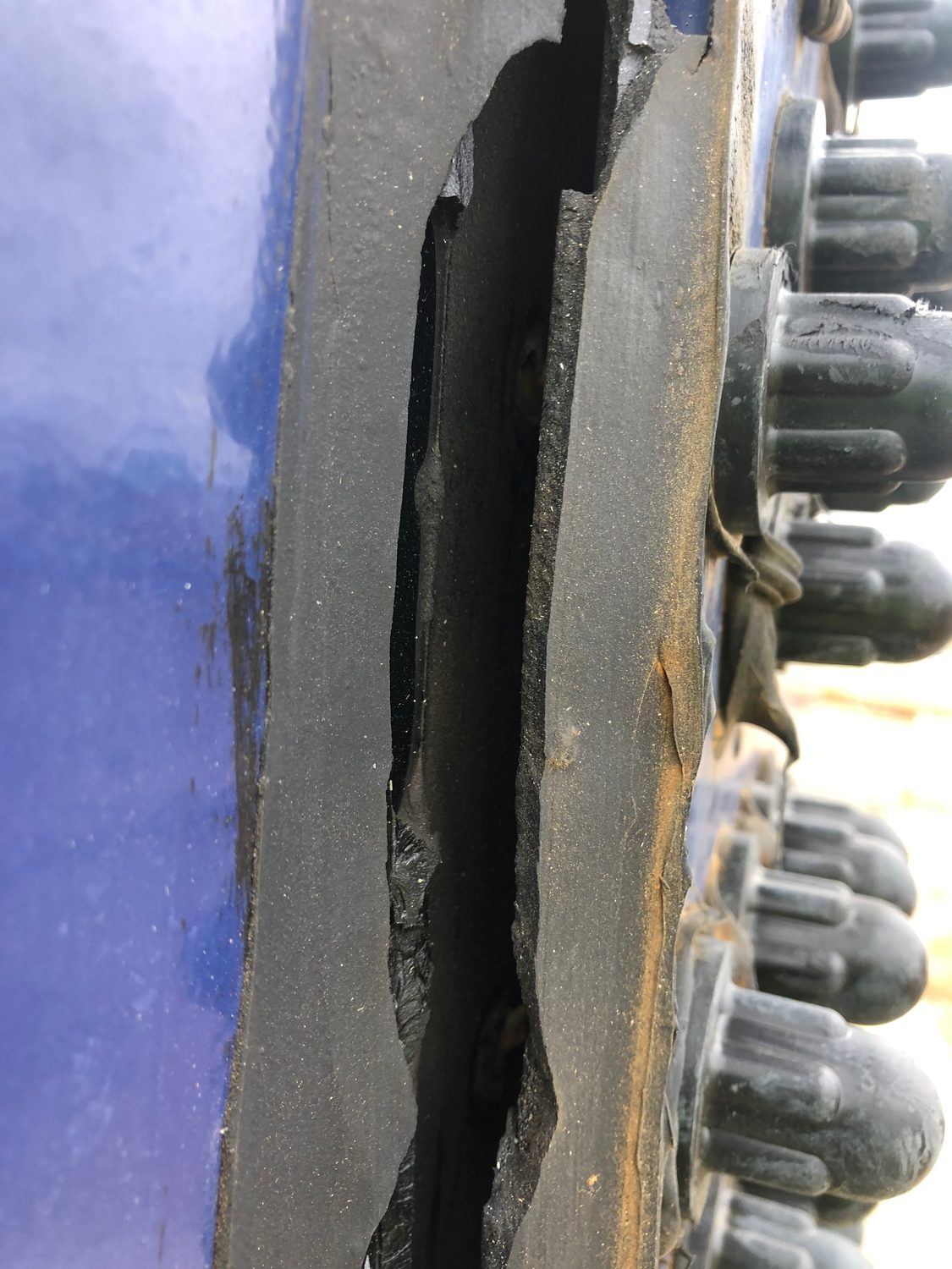 Open gap in failed sealant along a bolted tank panel seam