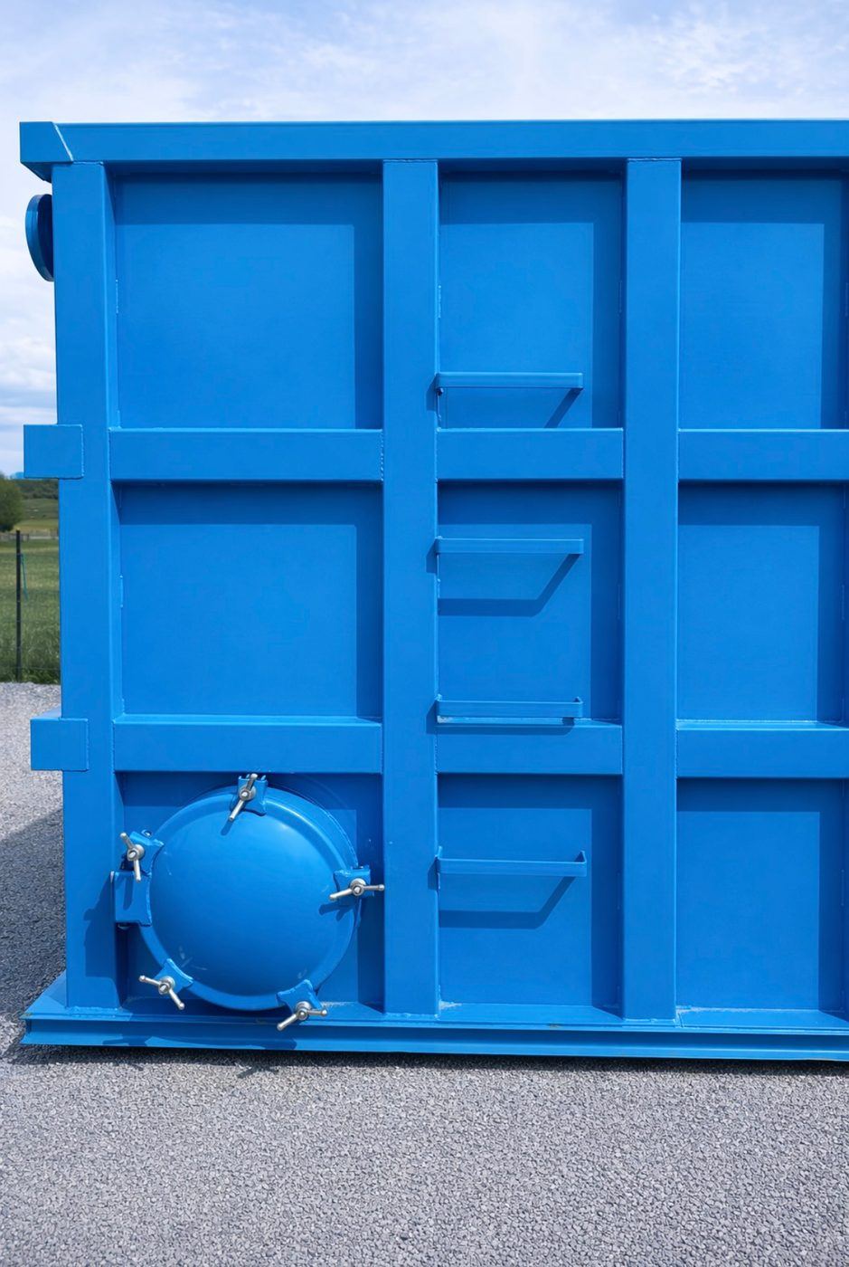 Close-up of a shop-welded steel tank end wall showing the reinforced panel grid and a bolted circular manway