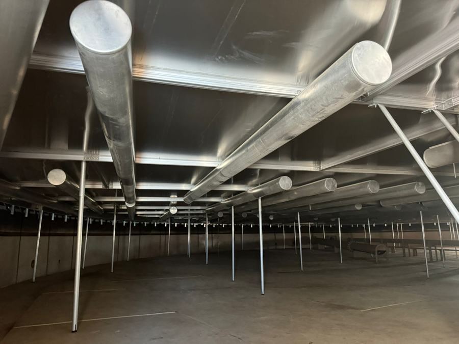 Underside of an aluminum floating cover showing pontoon tubes and support legs