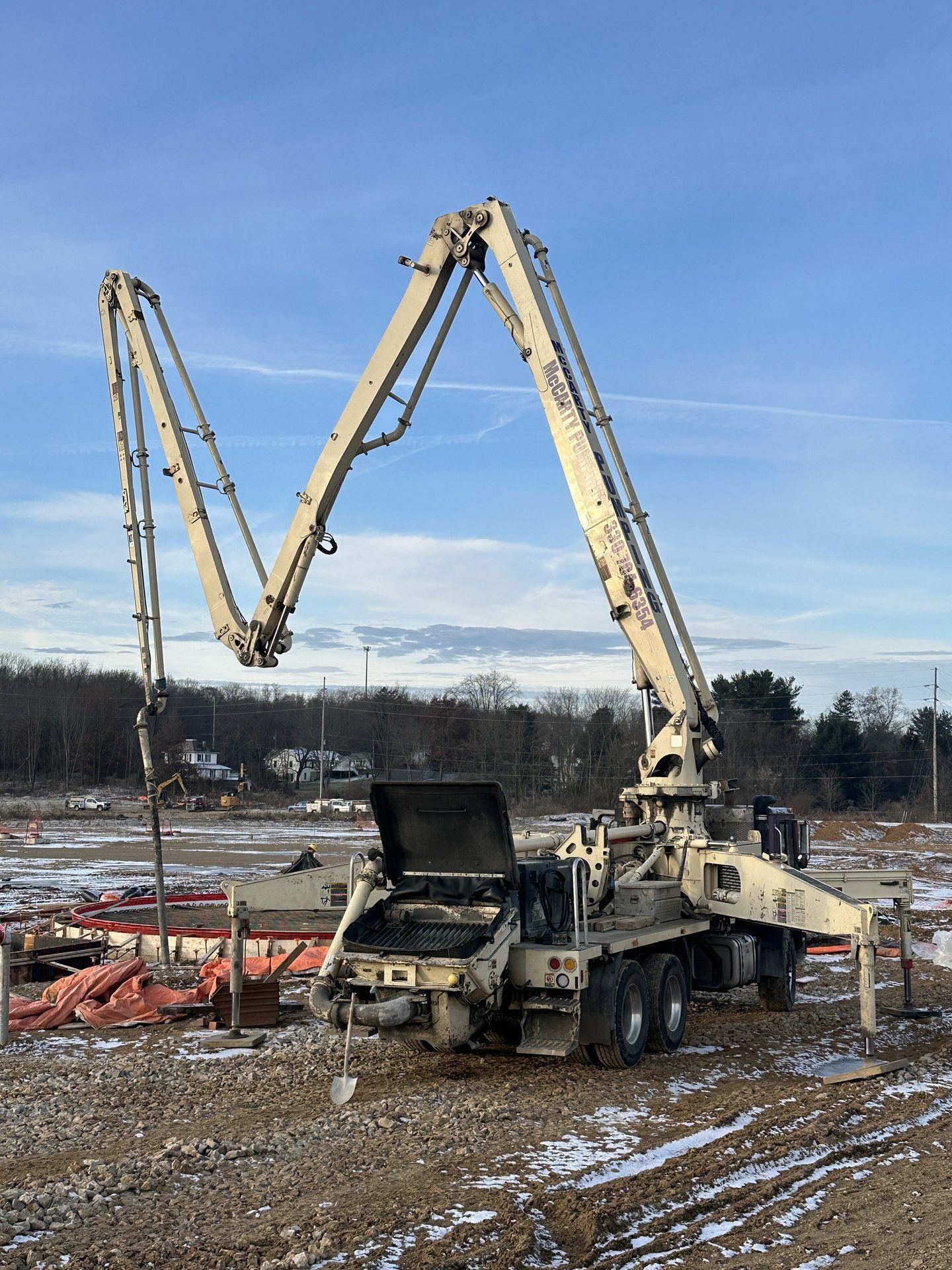 Concrete pump staged at a tank foundation jobsite
