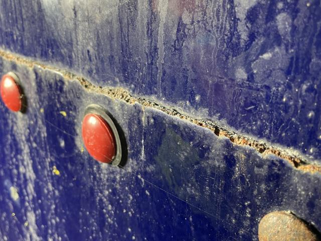 Weeping bolted seam with mineral tracking on a blue bolted steel tank shell