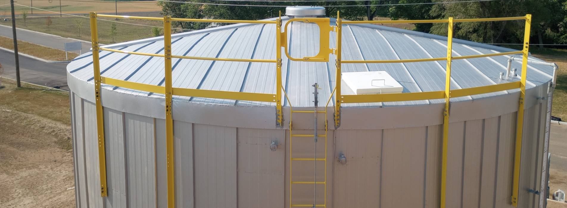 Insulated storage tank with vertical standing seam sidewall panels and a standing seam roof system