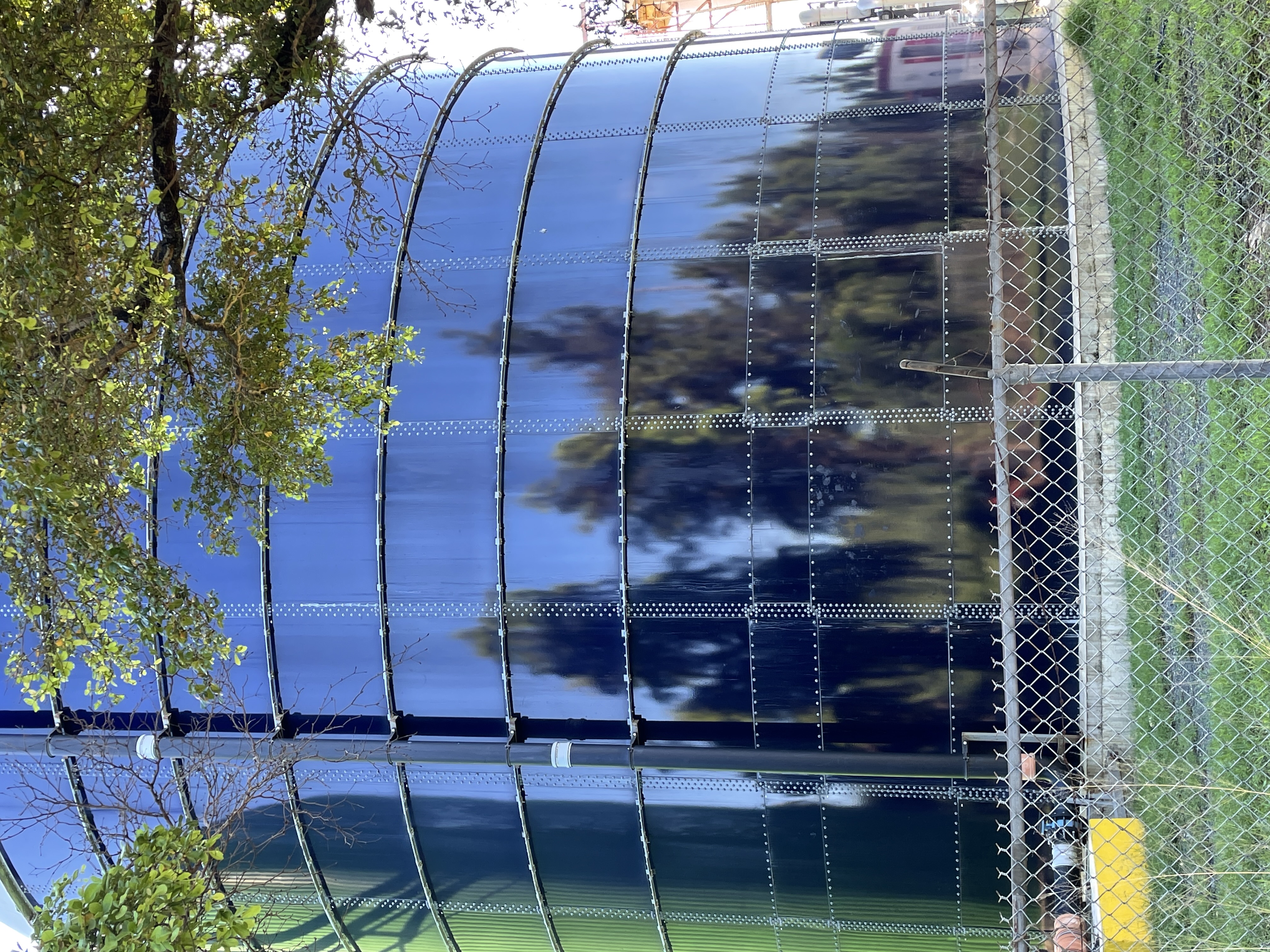 Glass-fused-to-steel bolted tank shell viewed from outside the site fence