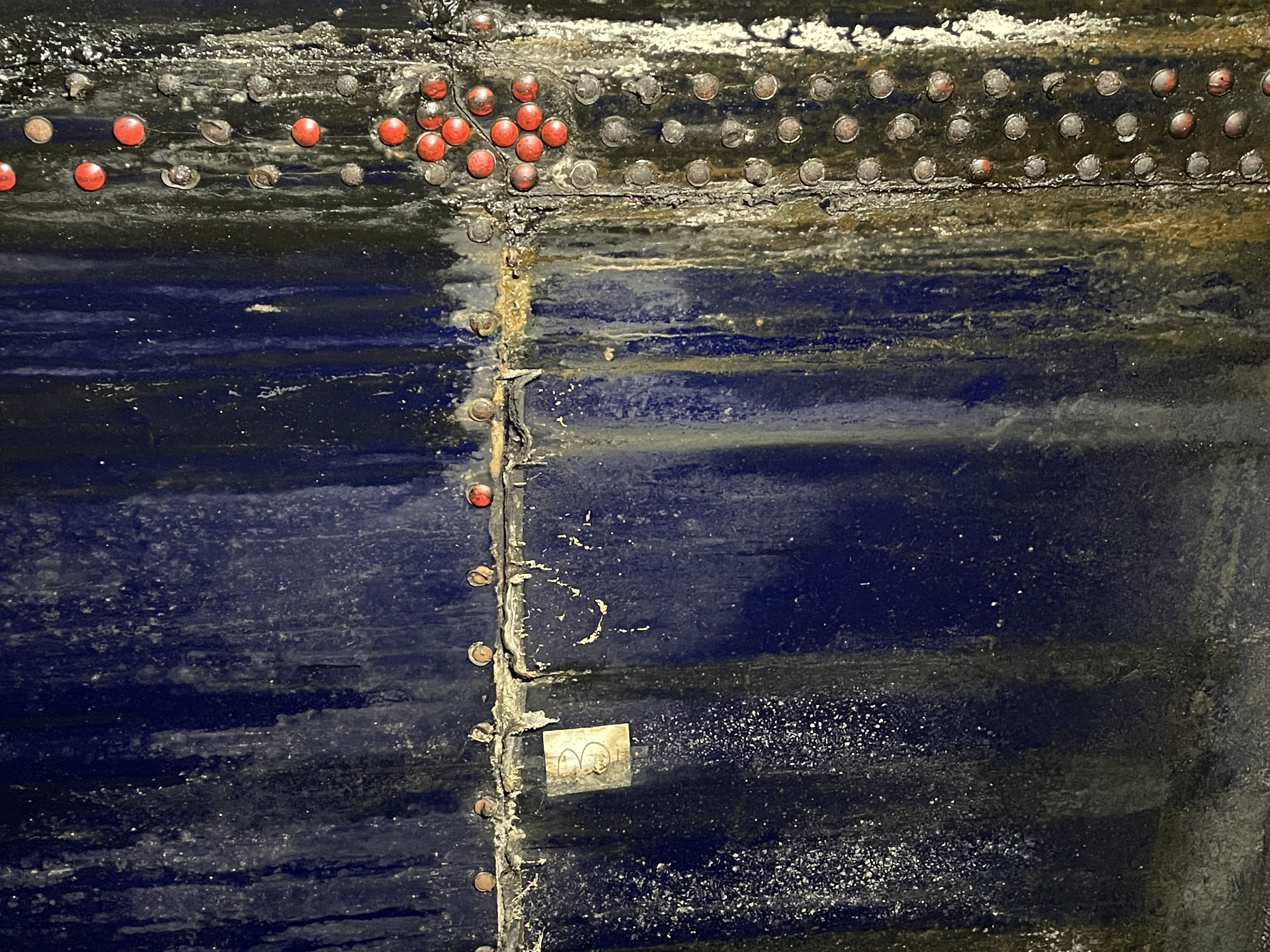 Interior tank wall showing seam, fasteners, and corrosion staining
