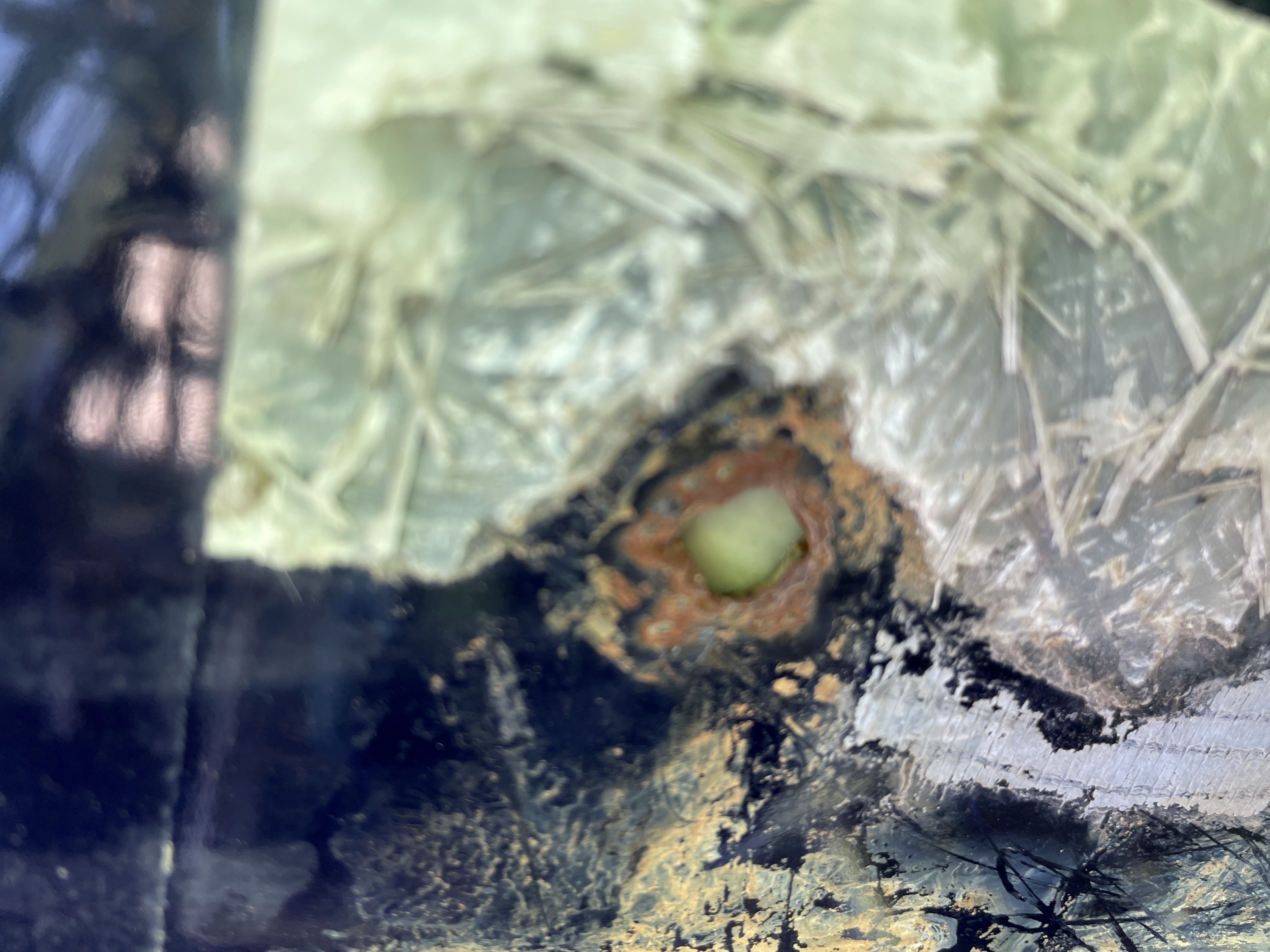 Corroded penetration with rust pinhole beneath a fiberglass patch