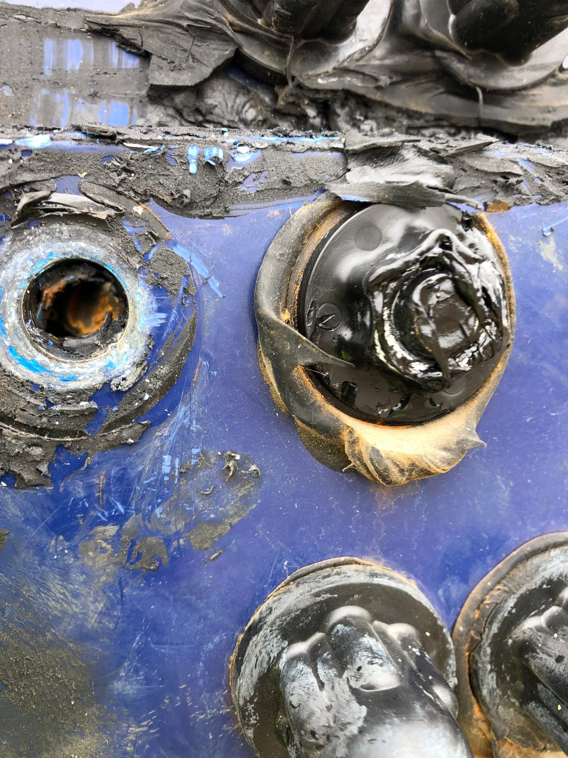 Corroded tank penetration with over-applied sealant repair