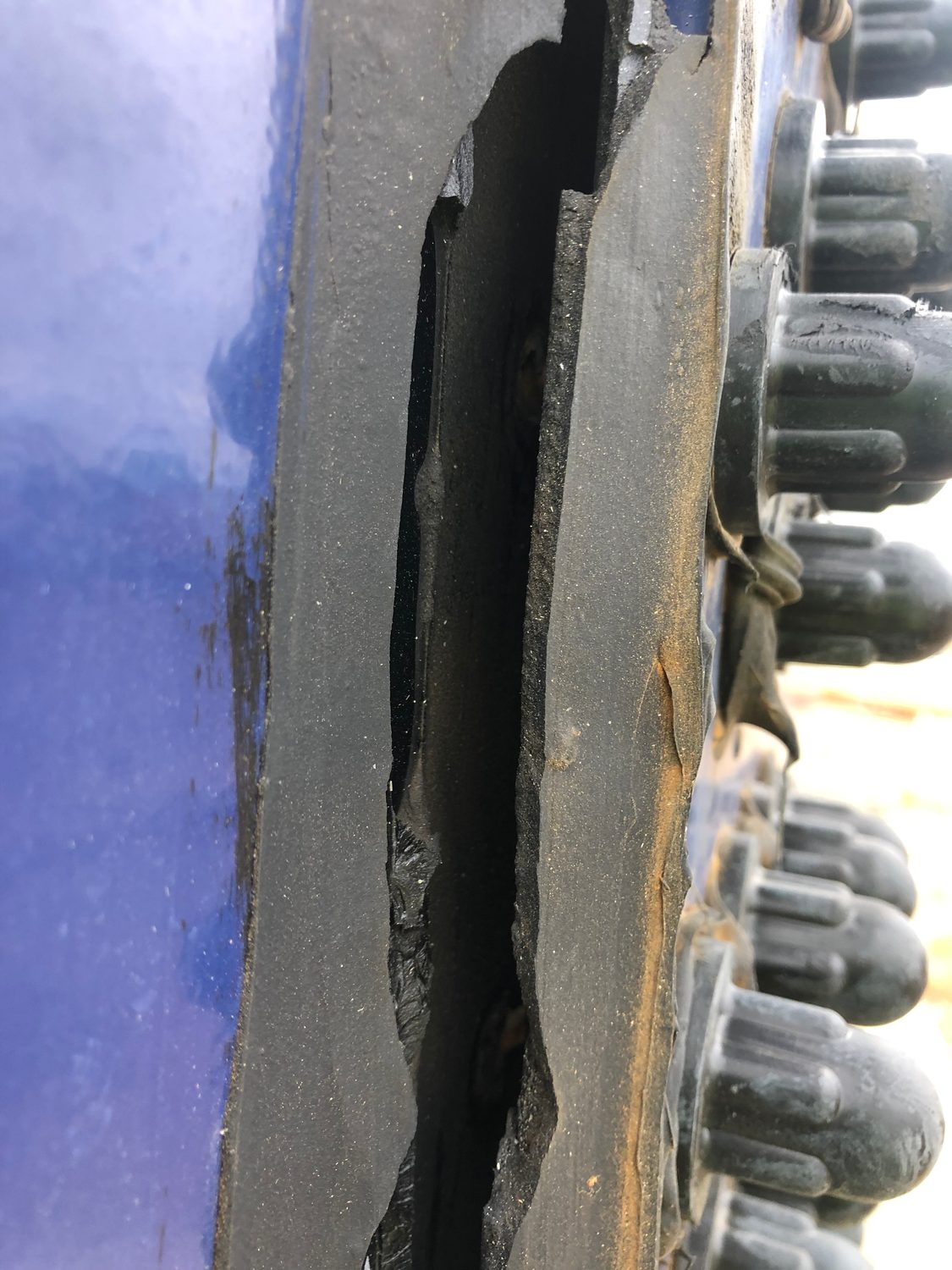 Open gap in failed sealant along a bolted tank panel seam
